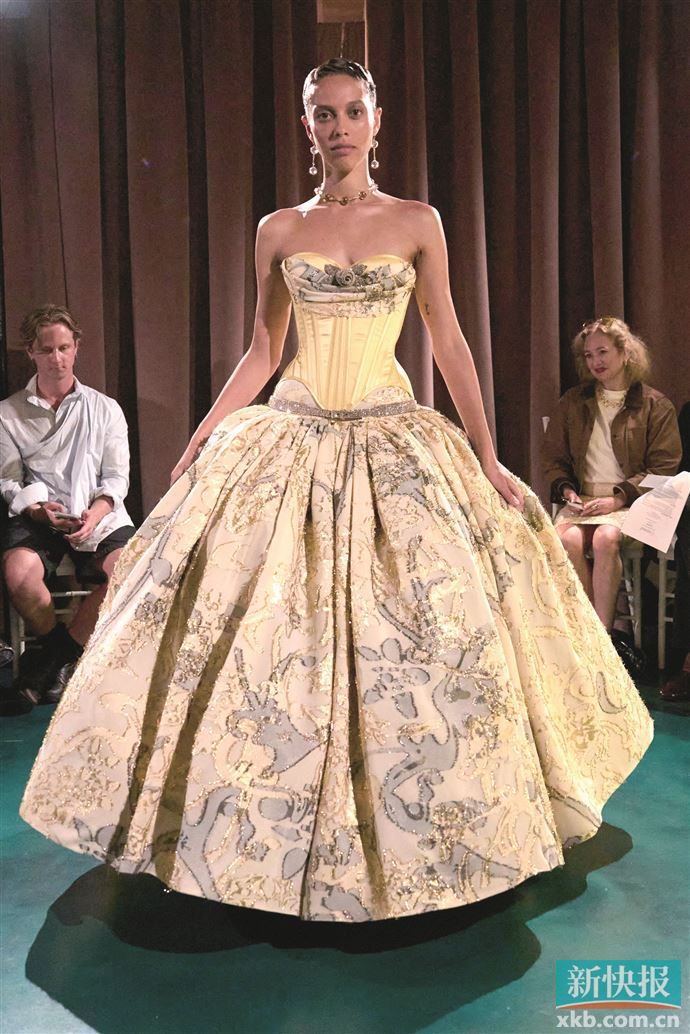 紧身胸衣式上装与阔摆裙摆形成鲜明对比，行走时裙摆如花瓣般舒展，巧妙平衡柔媚与力量感。