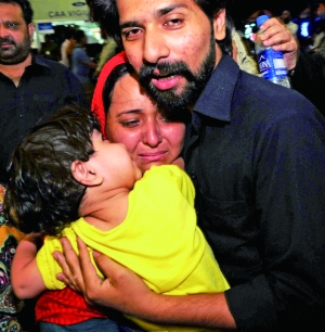 从也门撤离的巴基斯坦人到达巴基斯坦卡拉奇的机场后与亲人拥抱